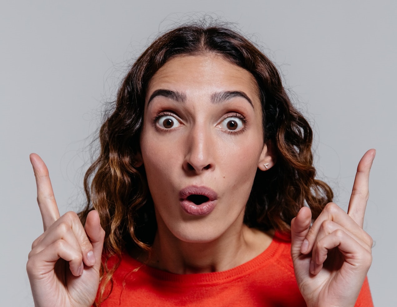 Surprised woman pointing up.