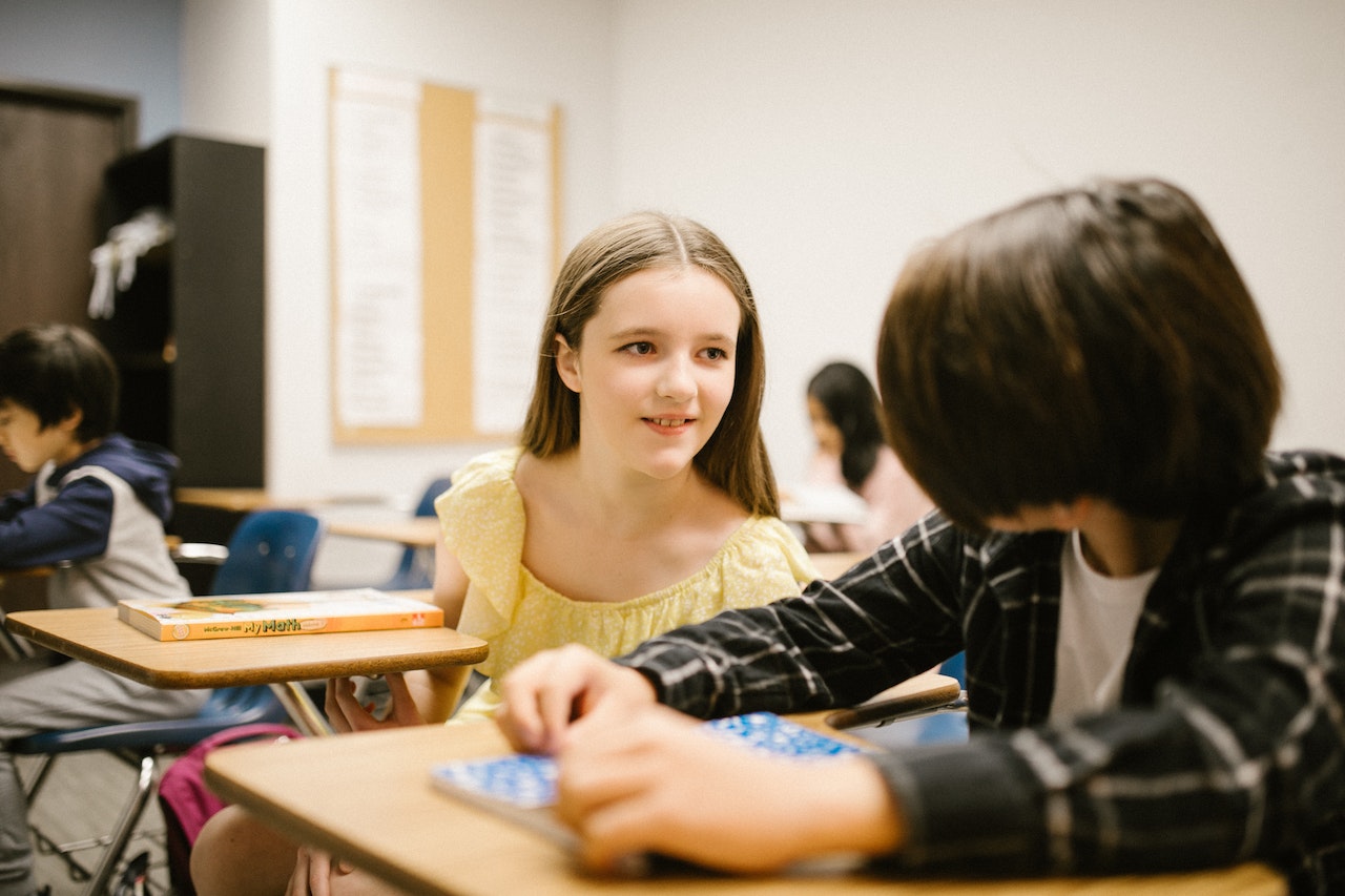 Girl in yellow shirt talking to a boy 