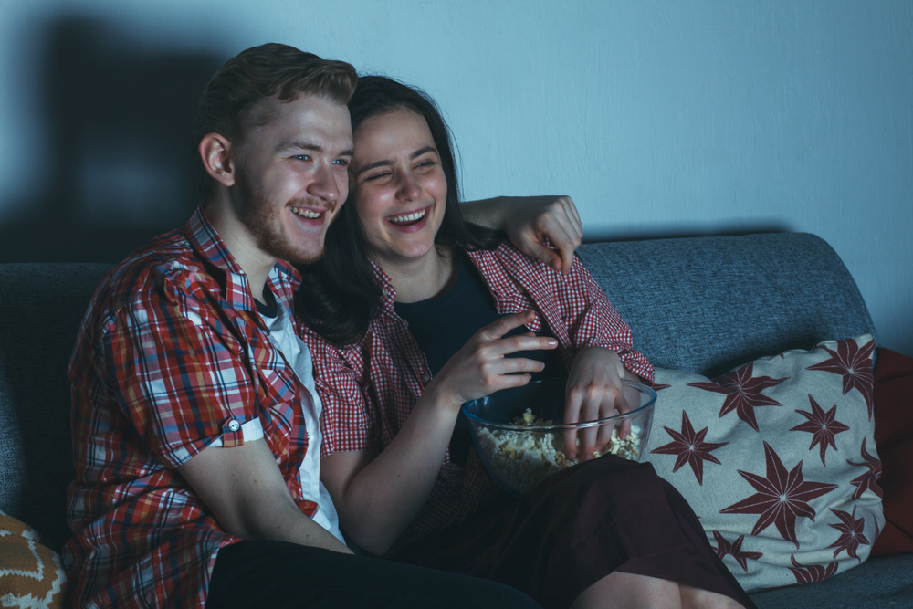 Young couple watching movie on sofa