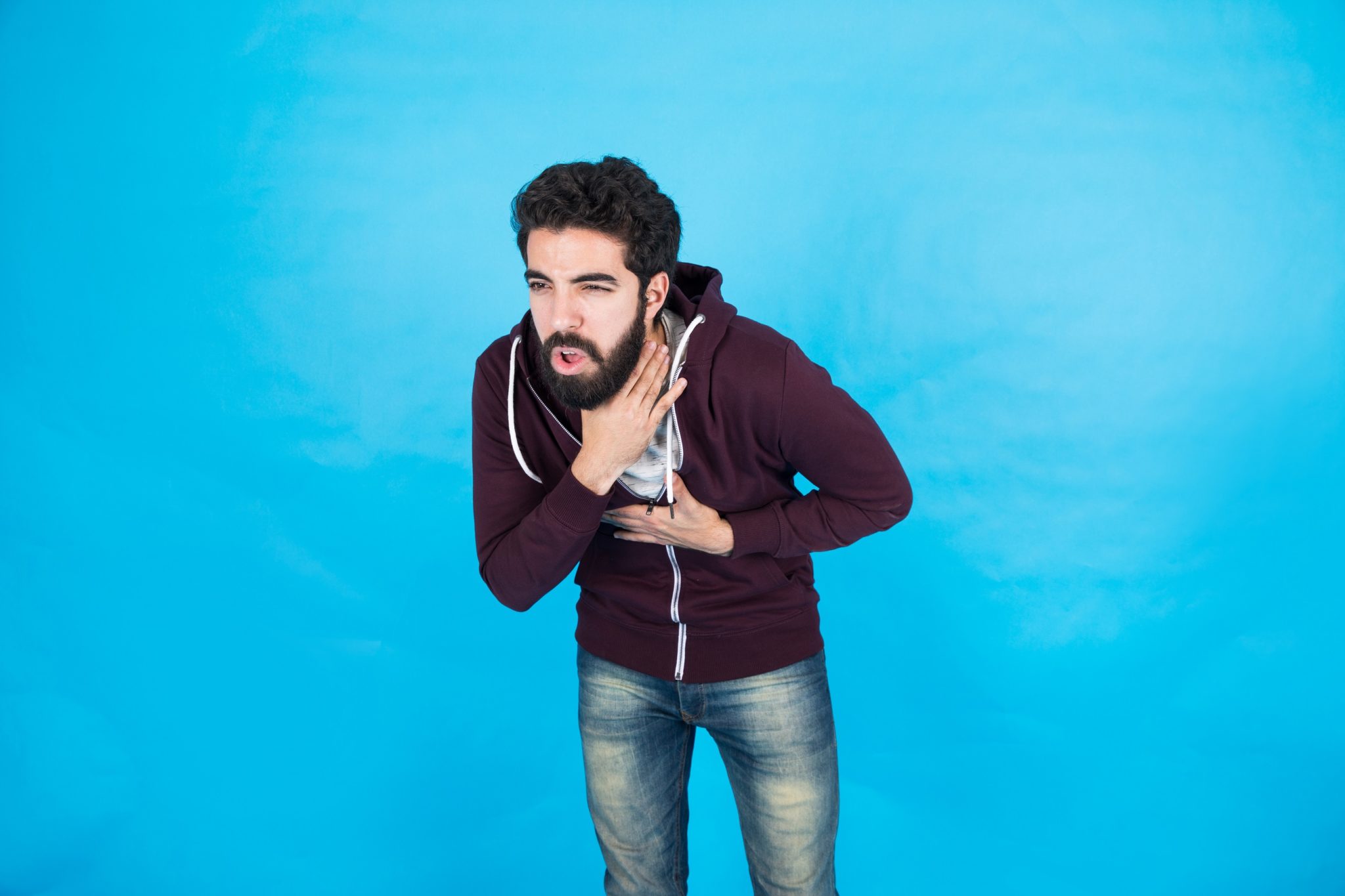 Man with beard choking and holding his neck