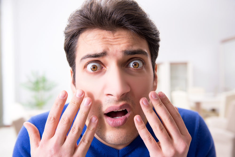 Shocked man in blue blazer entering bathroom