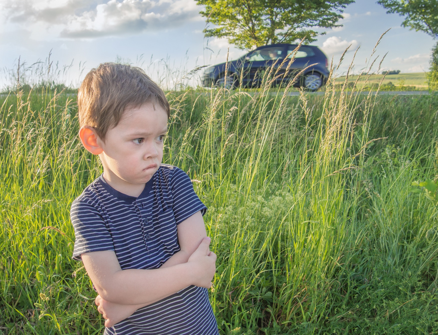 Sad kid seating by the road.