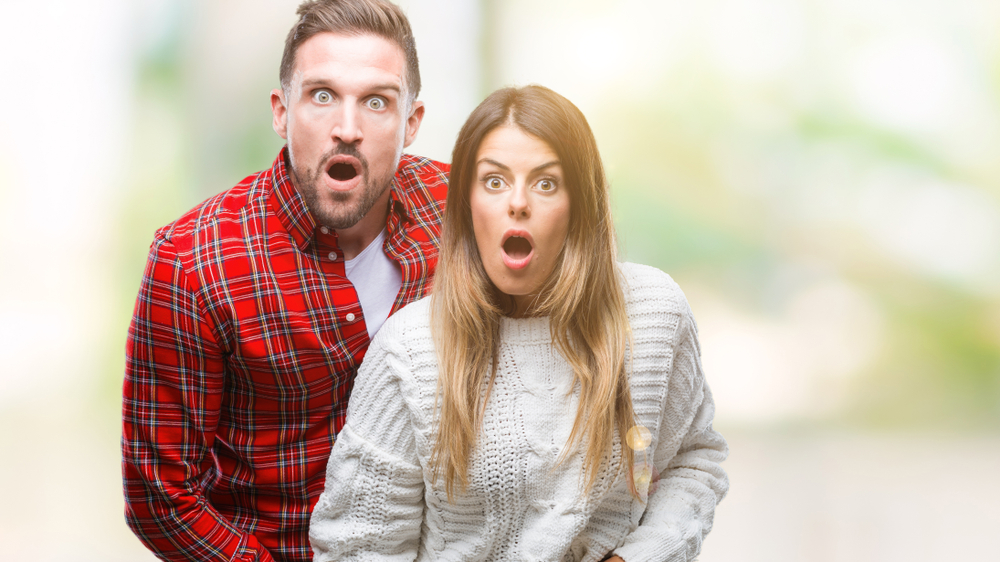 Shocked young couple with open mouths gesture 