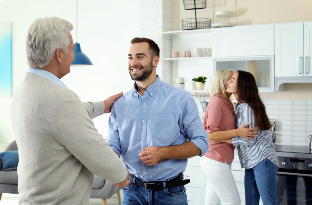 Smiling young man in blue shirt meeting his girlfriend's father