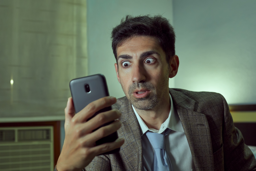 Shocked man looking at his phone