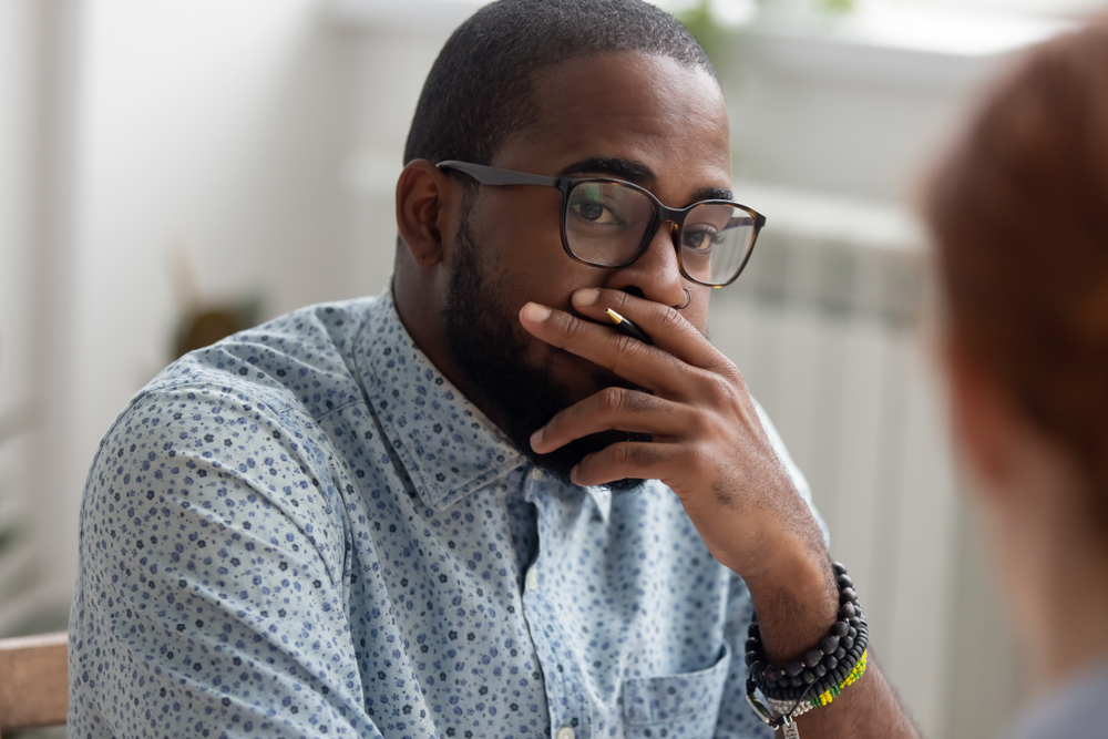 Shocked man with hand over mouth in office