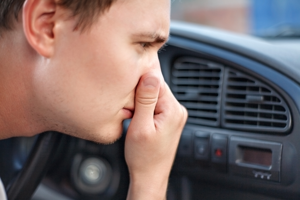 Man driving and feeling bad smell in his car