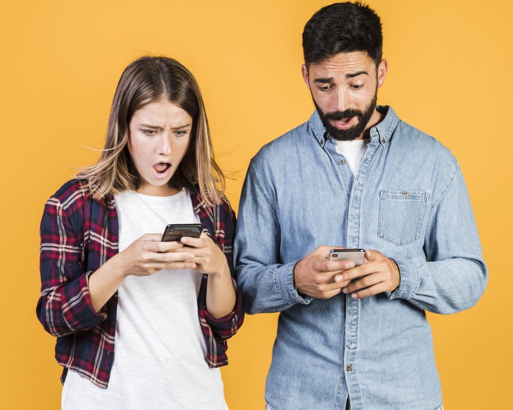 Shocked couple on their phones