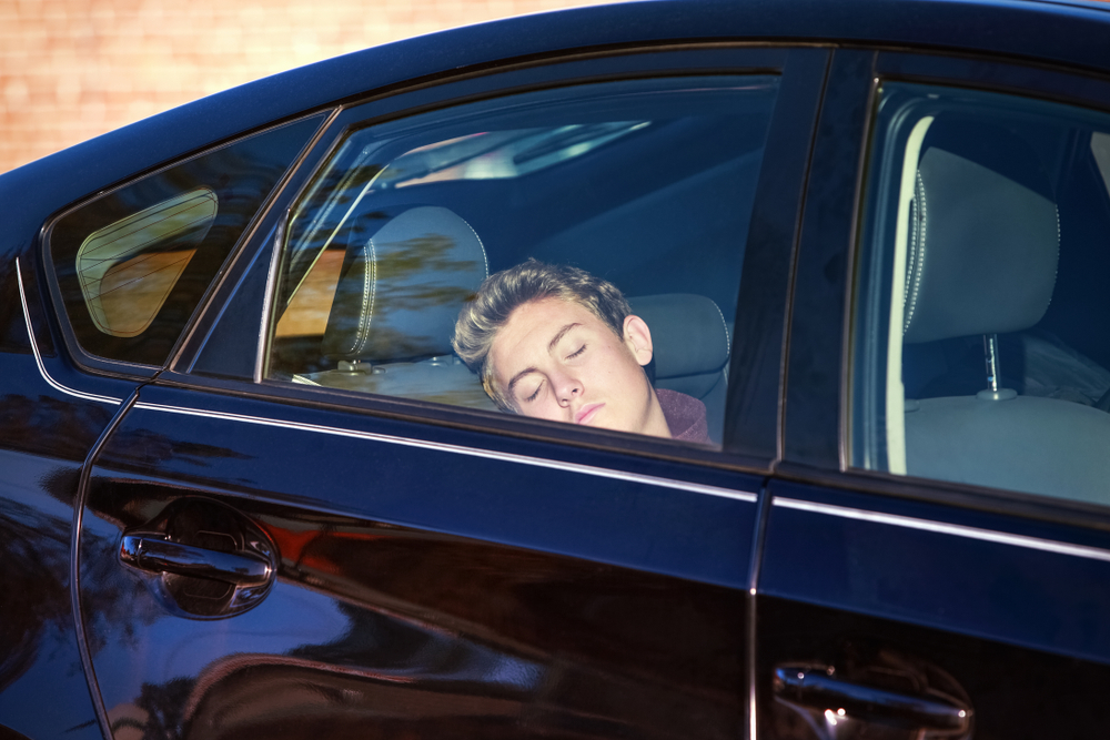 Teenager sleeping in car