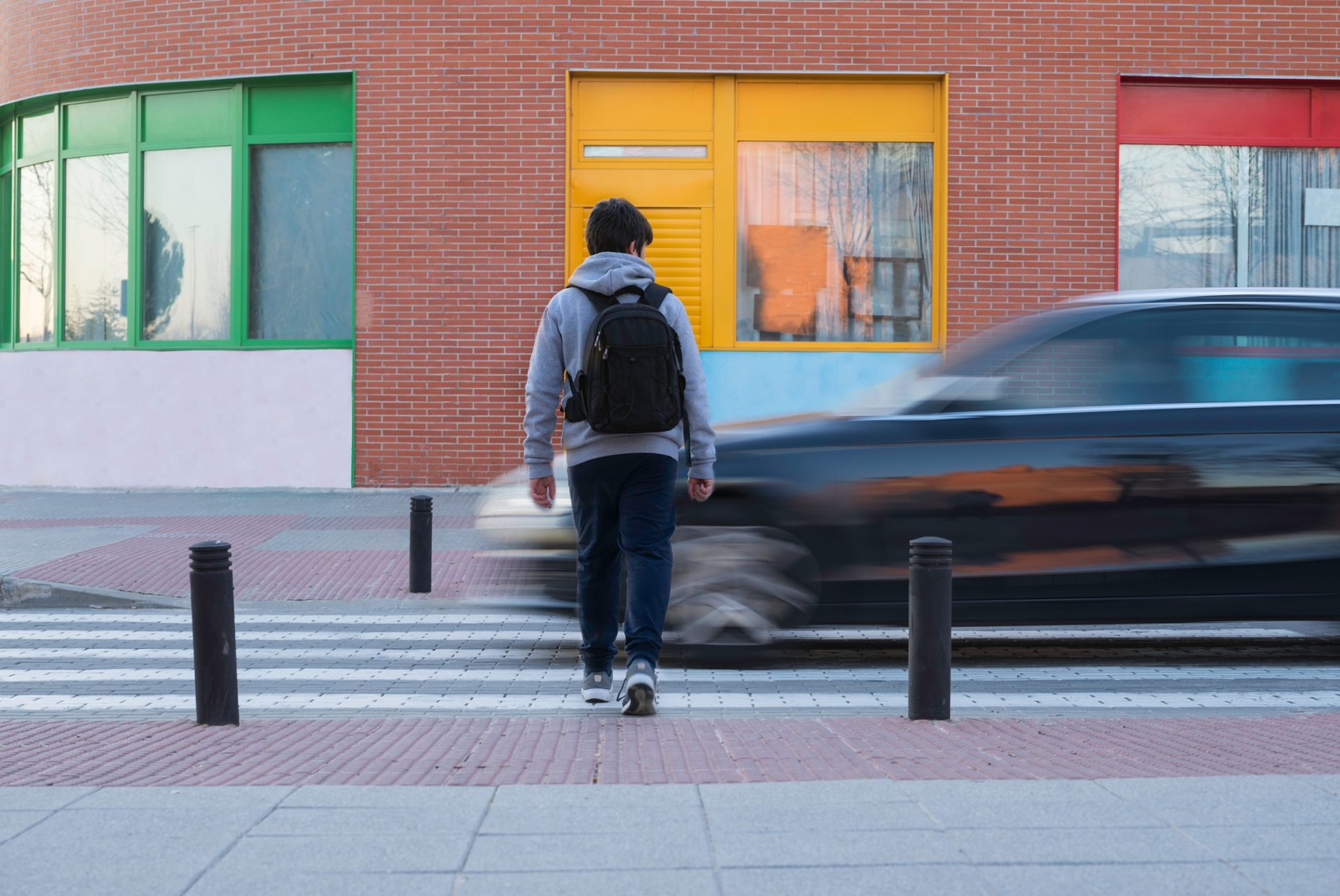 Kid crossing a busy street.