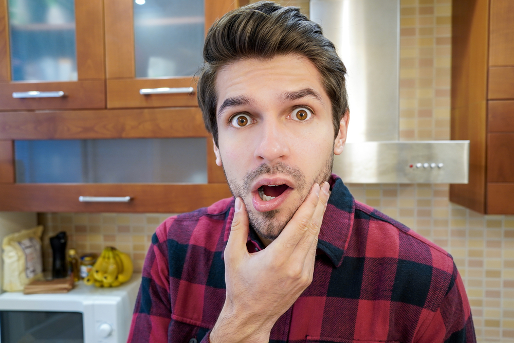 Shocked and surprised man in kitchen 