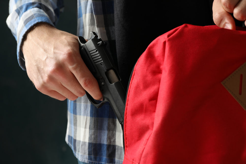 Teenager hiding gun in a backpack