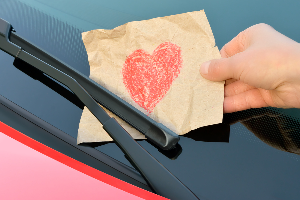 Paper with red heart drawn on it put behind car windshield