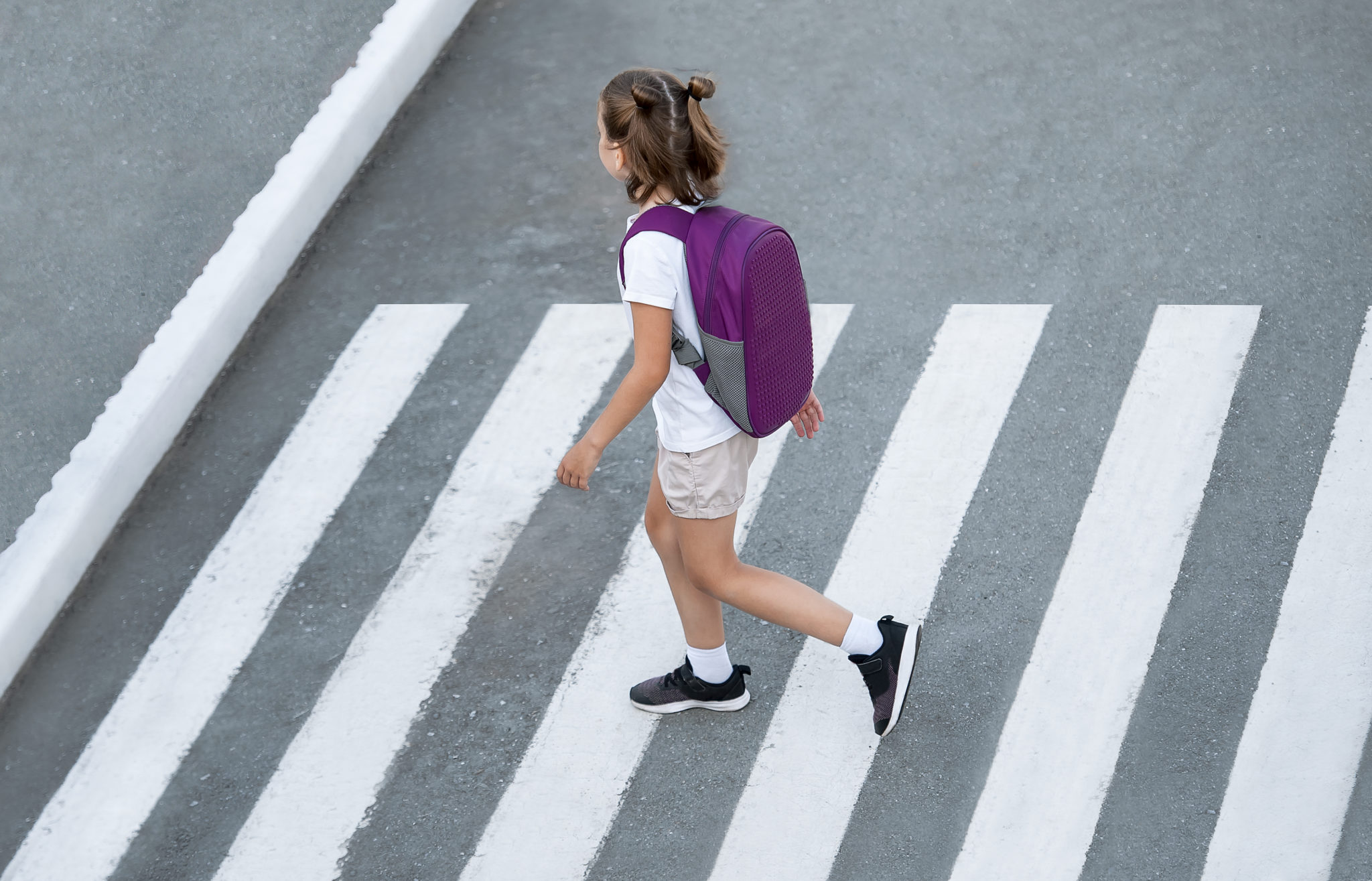 Stylish young girl crossing road.
