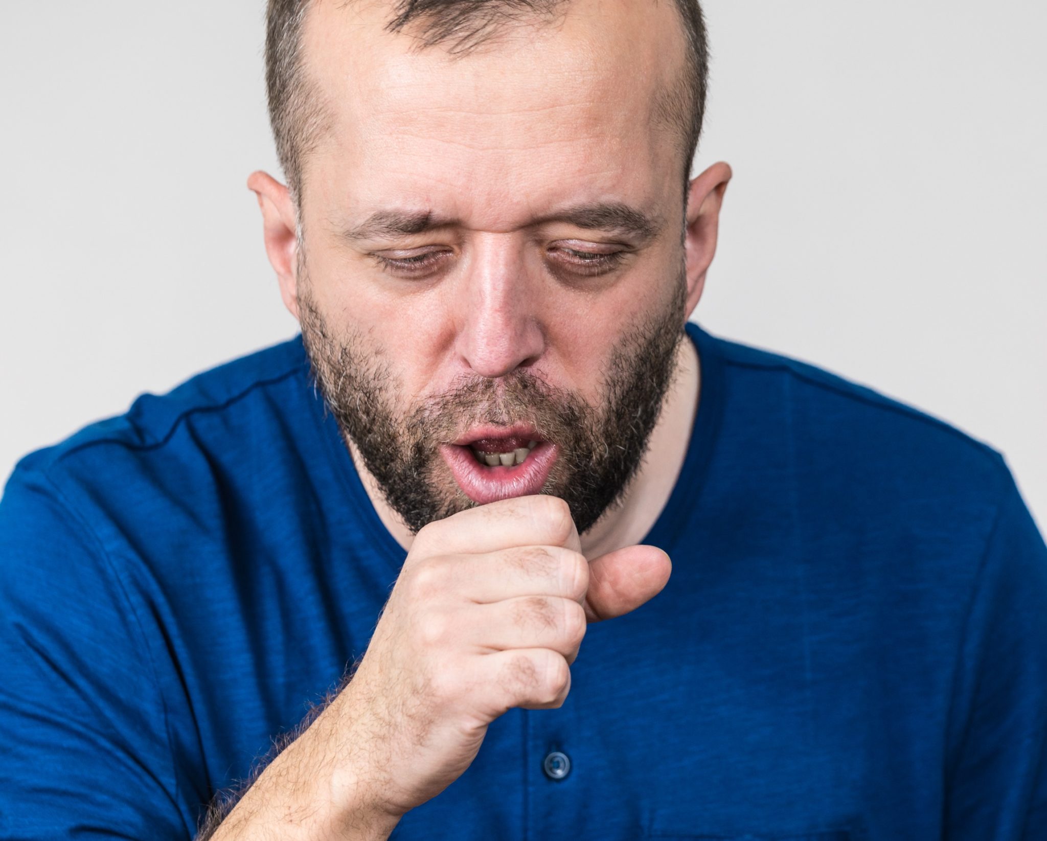 Bearded man coughing and choking