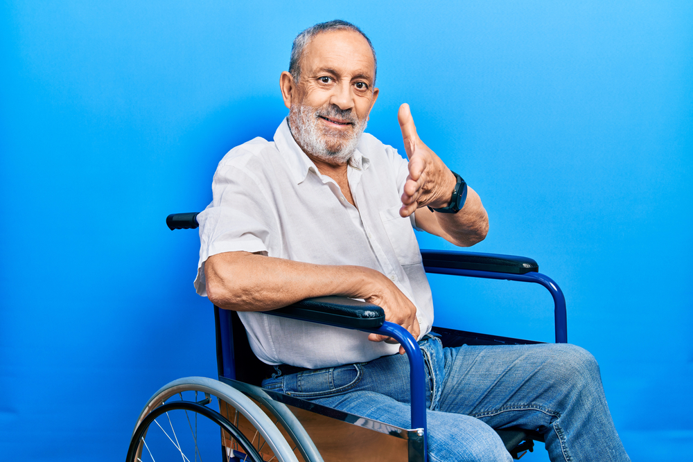 Man in wheelchair offering handshake