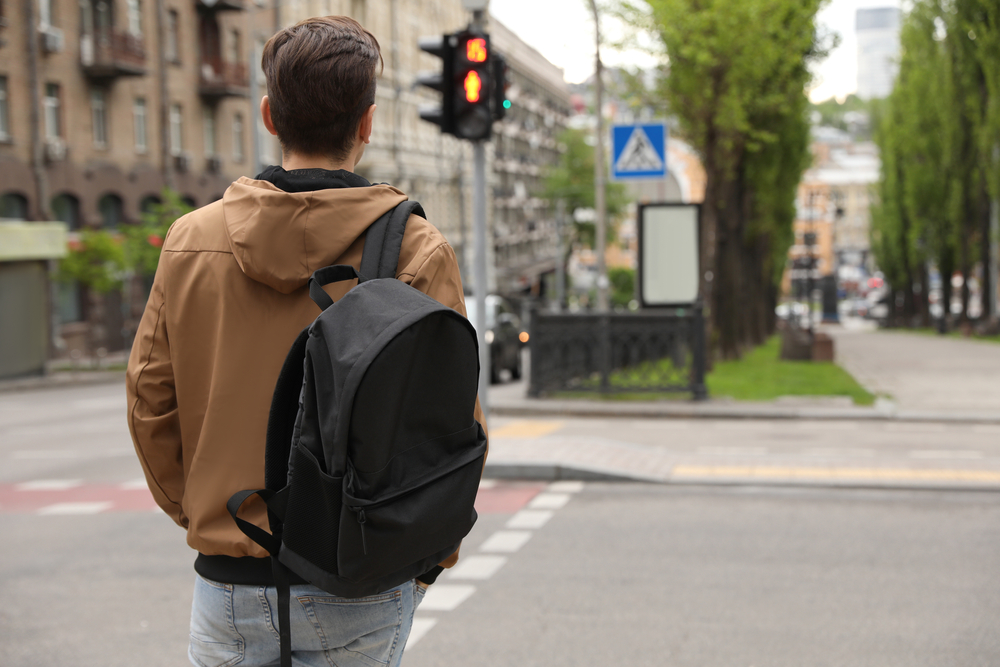 Young man waiting for traffic lights to cross street