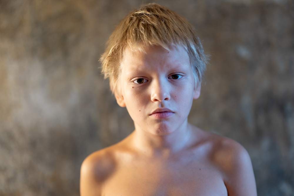 Confused blond boy woke up in morning at home