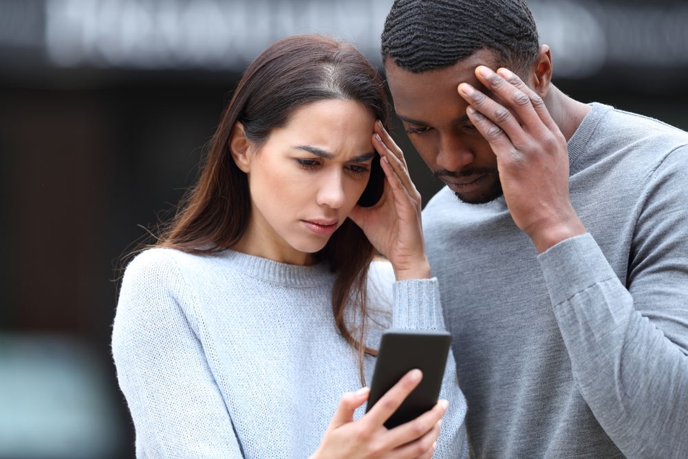 Worried couple looking at a phone