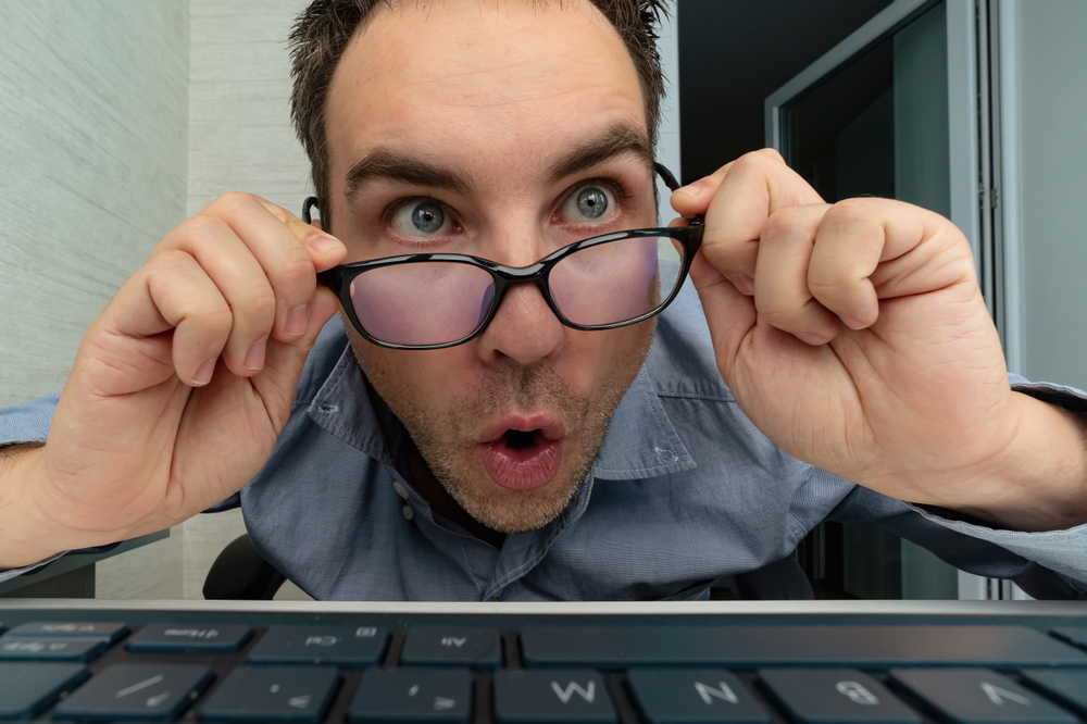 Shocked man in office looking at his computer