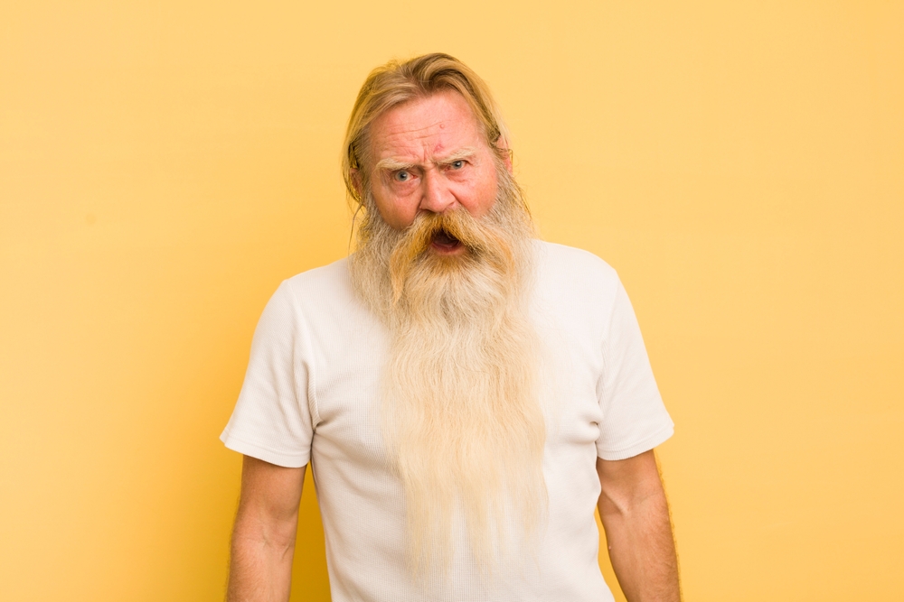 Senior bearded man looking shocked, angry, annoyed or disappointed, open mouthed and furious