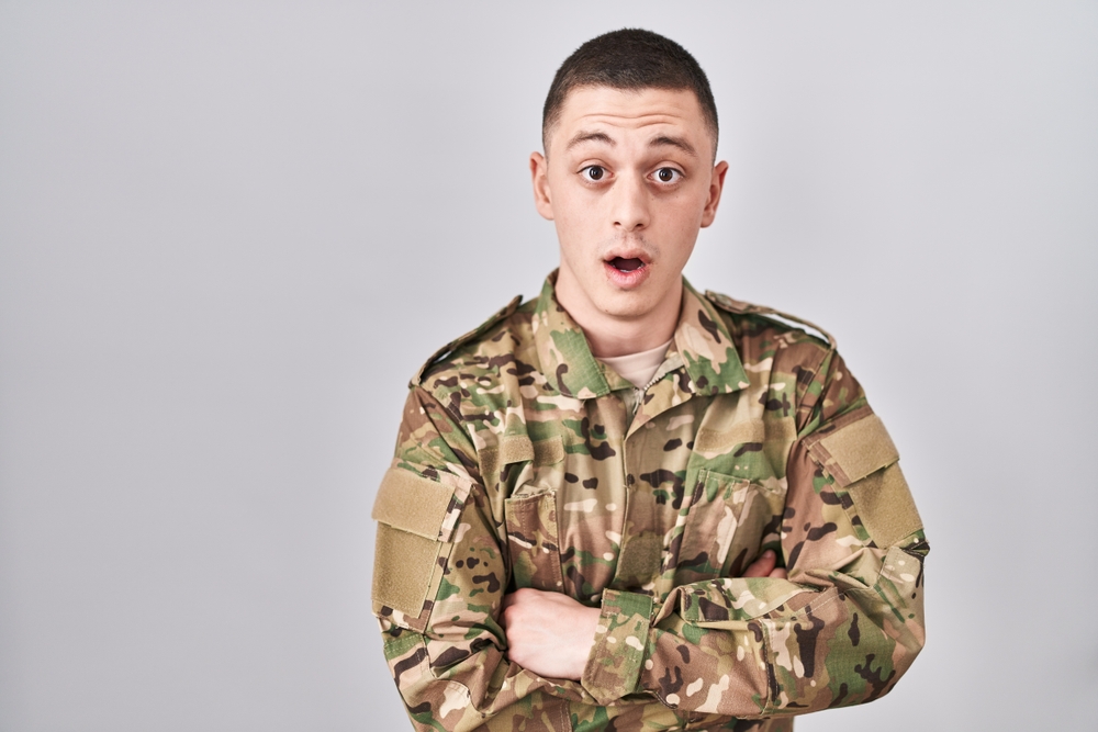 Shocked soldier in uniform with crossed hands