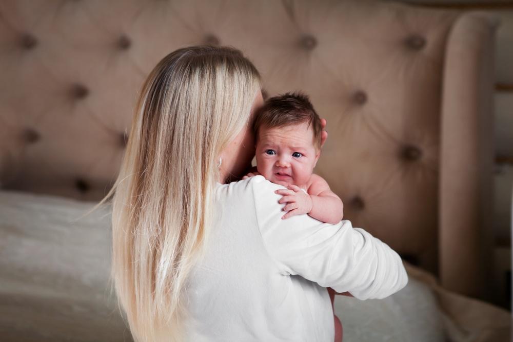 Mom holds scared, crying newborn baby 