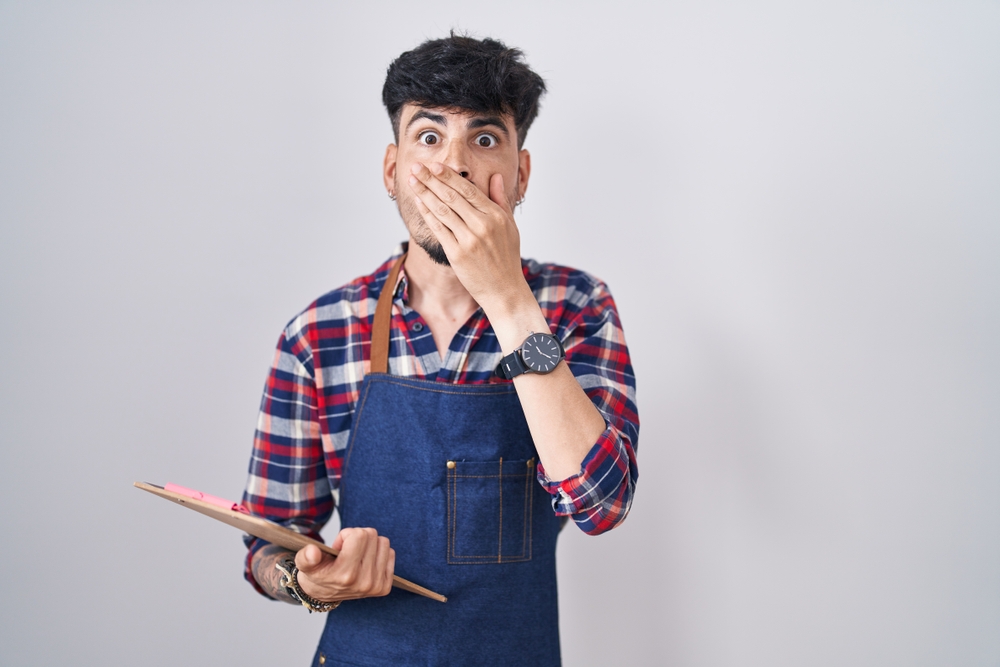 Embarrassed waiter covering his mouth with hand 