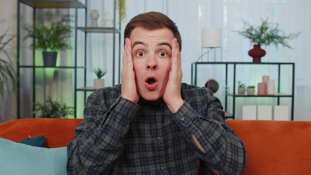Shocked man sitting on a couch