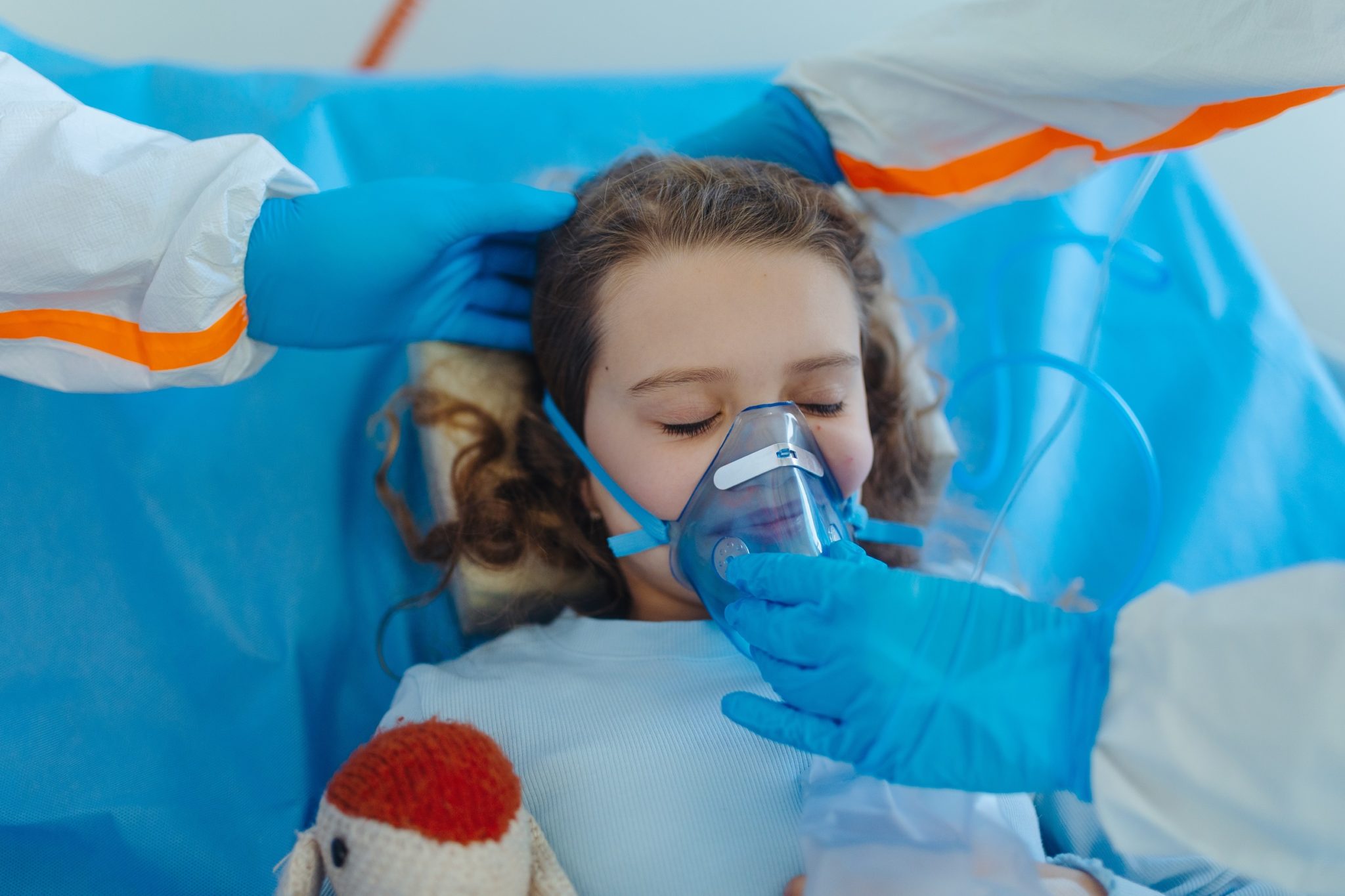 Girl in hospital wearing oxygen mask.