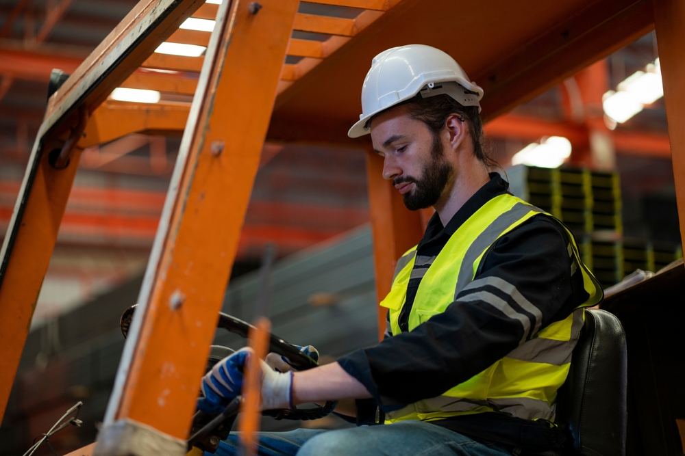 Male worker driving a forklift