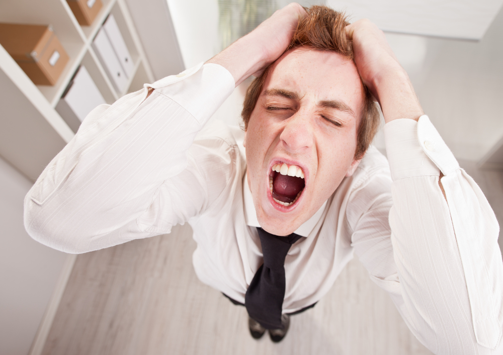 Angry man in office in suit yelling