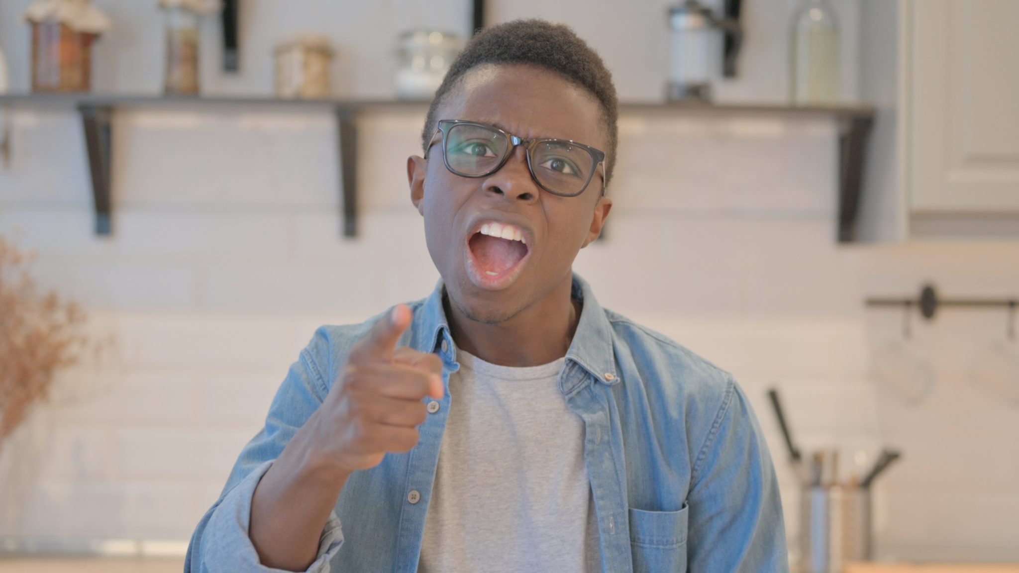 Angry young African kid arguing with other kid and pointing.