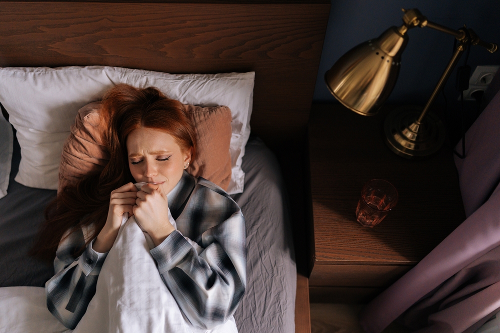 Scared woman lying in bed 