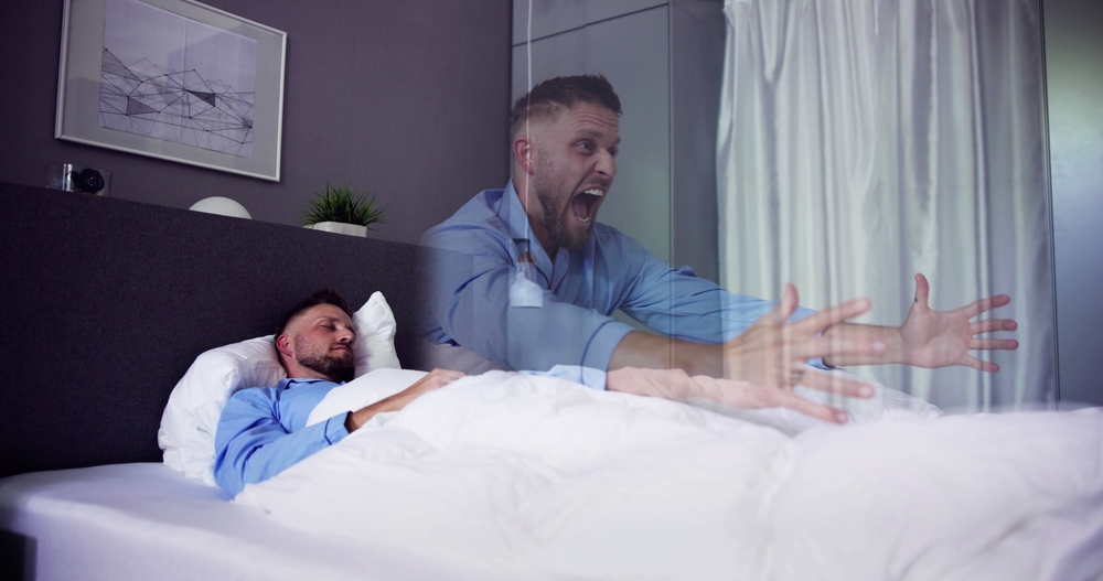 Scared man experiencing Sleep Paralysis
