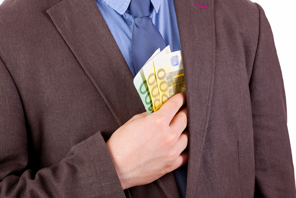 Man stealing money putting it in his pocket 