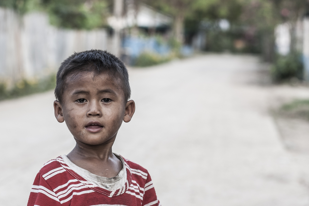 Poor child standing on a street