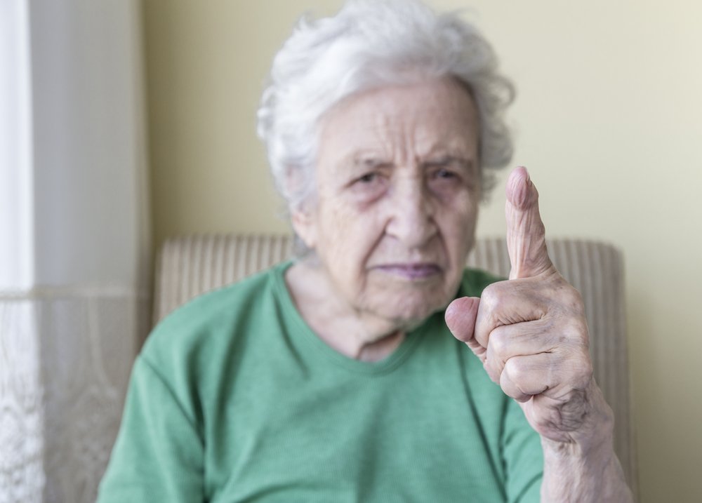 Angry older woman pointing finger at something