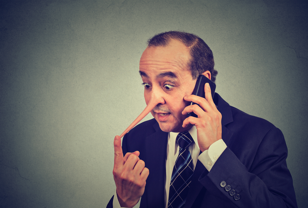 Middle aged man with long nose talking on mobile phone lying