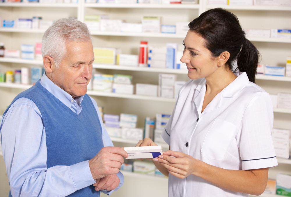 Pharmacist serving senior man in pharmacy
