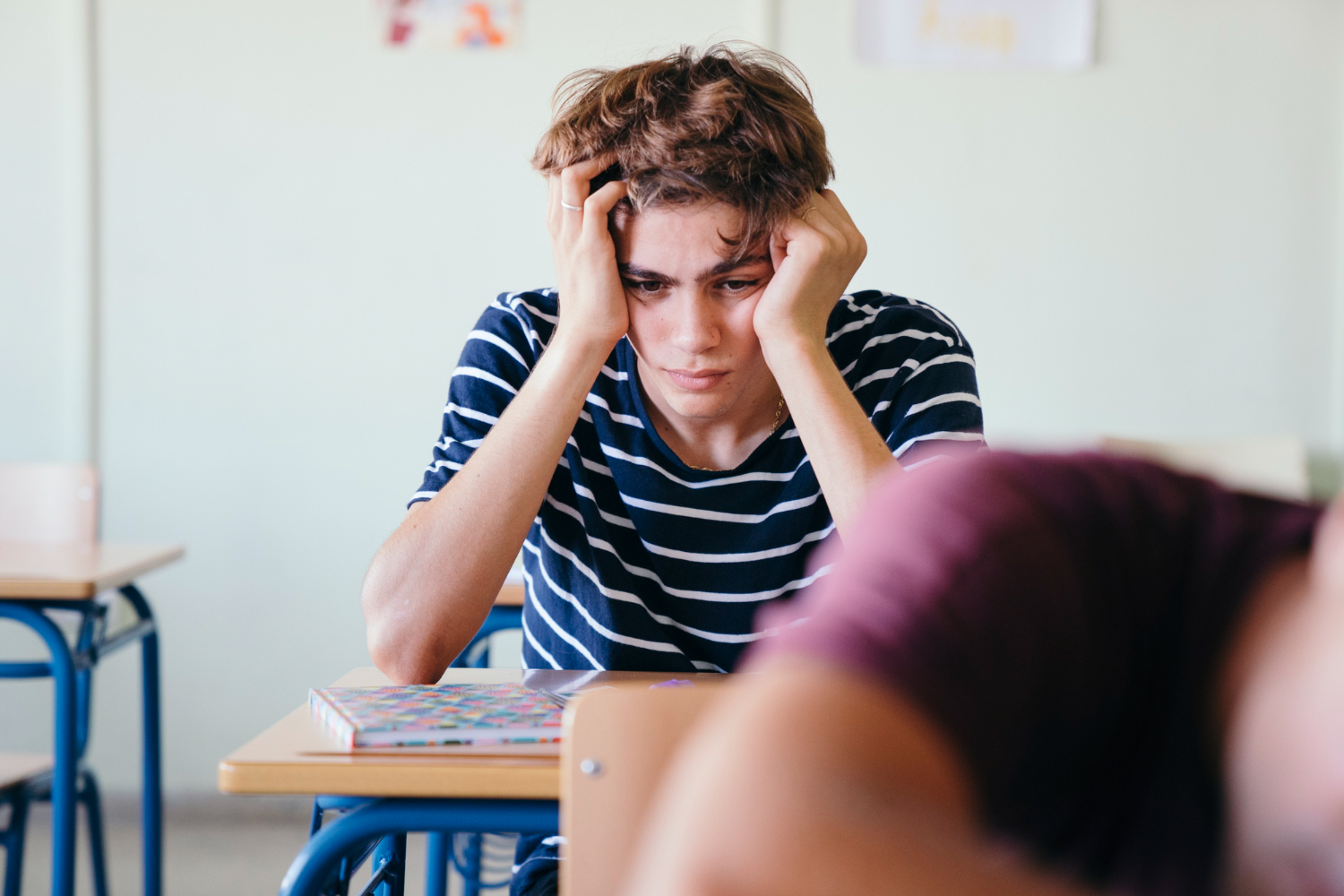 Sad kid at school desk