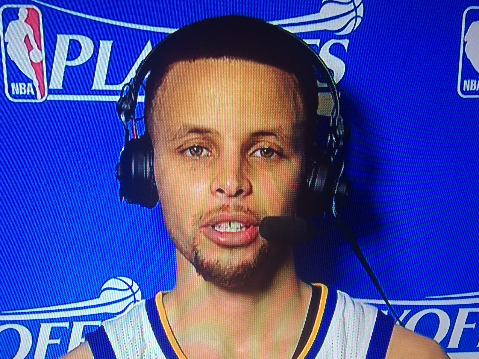 Steph Curry wearing headphones looking at camera.