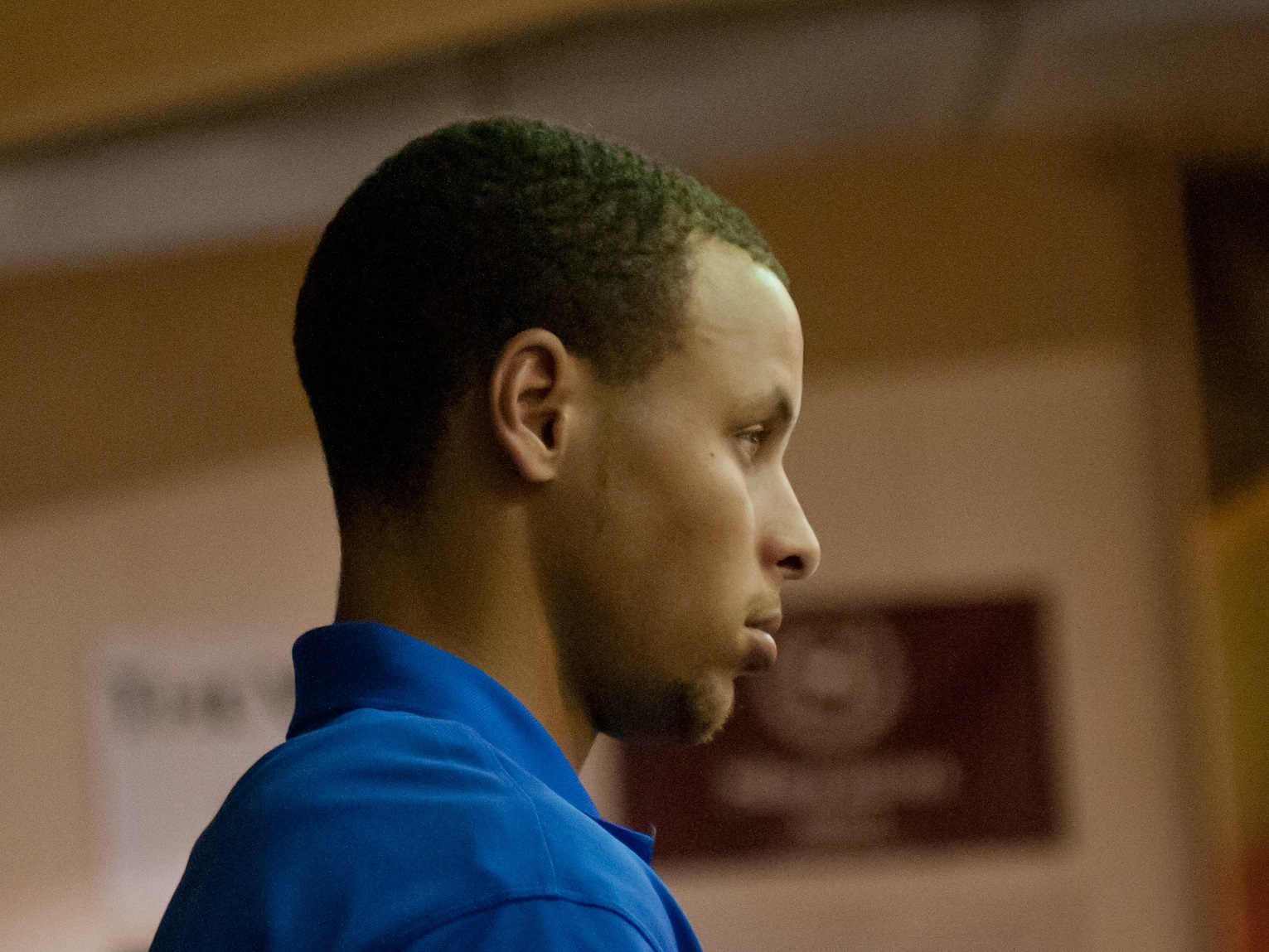 Steph Curry wearing blue jacket is looking at front.