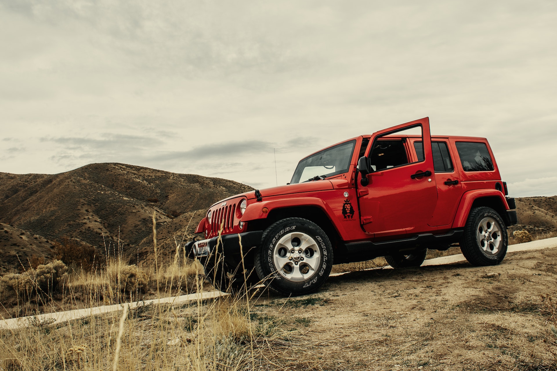 photo of red suv on dirt road