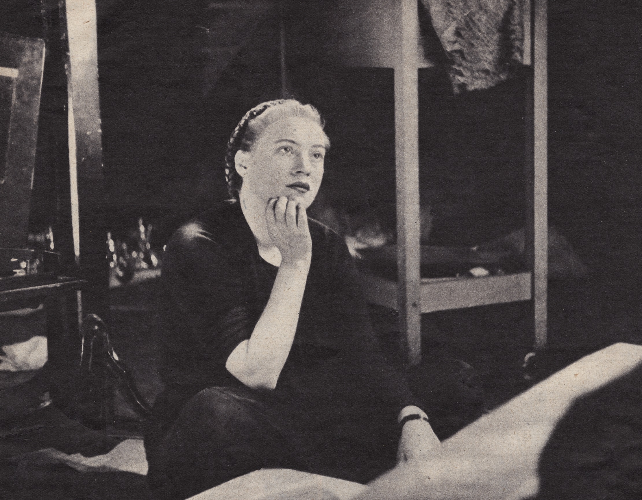 Lee Miller wearing black clothes is seating in studio - 1940