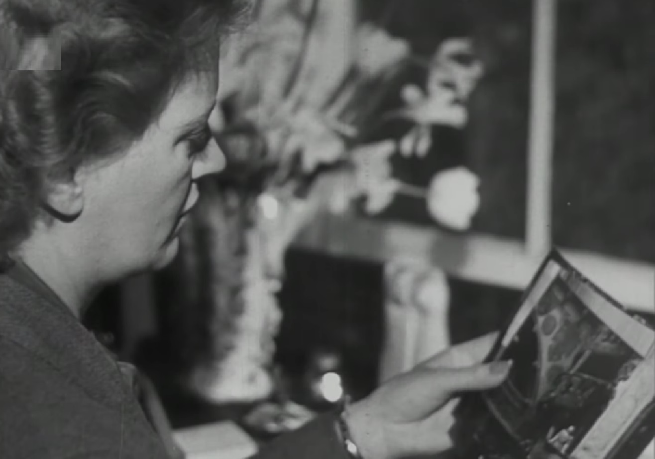 Screenshot: B&W Lee Miller is seating an looking at book - from Lee Miller- Through The Mirror (1955)