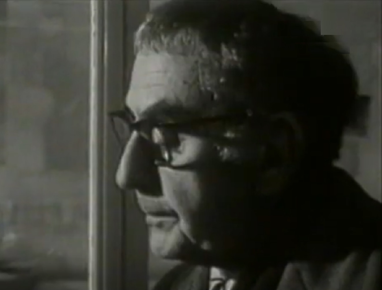 Screenshot: Man Ray wearing glasses is looking down - from Man Ray- Prophet of the Avant-Garde (1997)