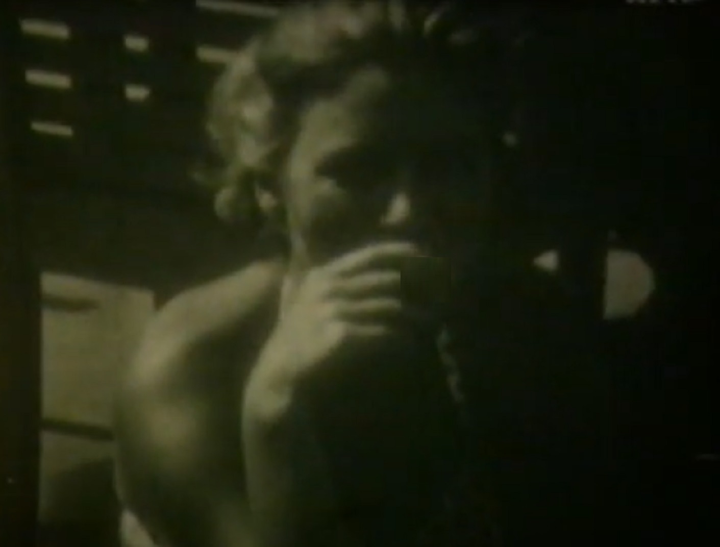 Screenshot: B&W Lee Miller seating outside and looking down  - from Lee Miller: Through the Mirror (1955)