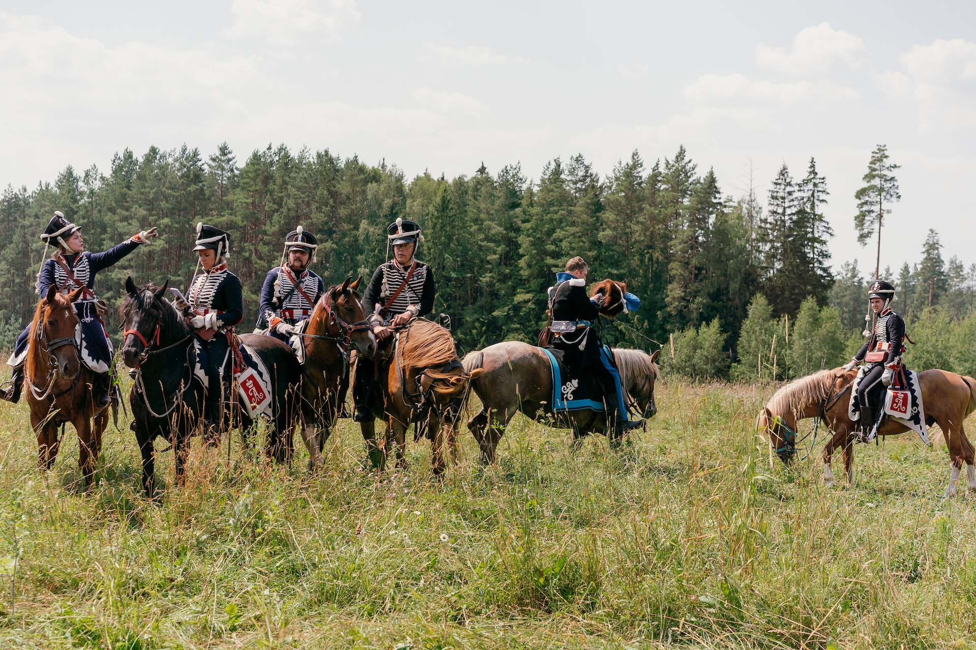 soldiers ridding brown horses on a grass field