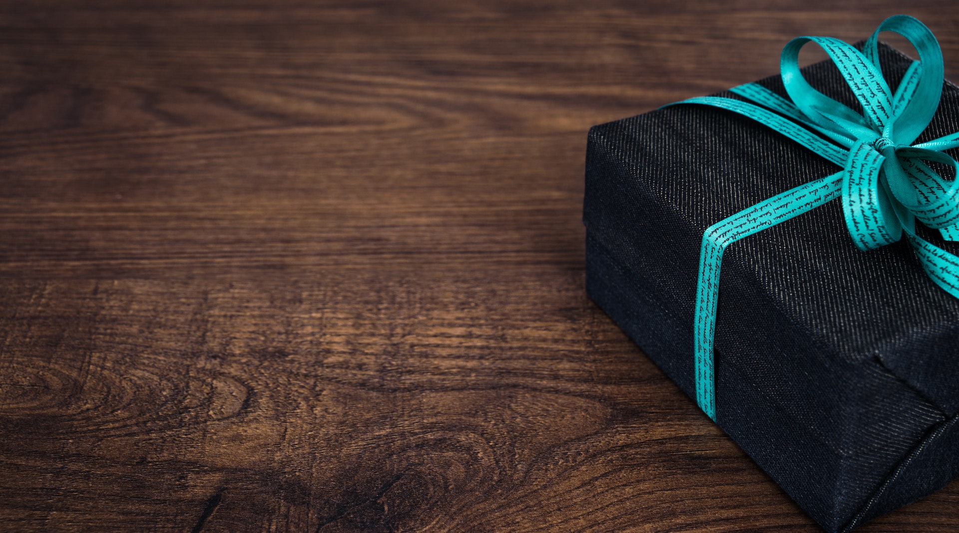 present folded in black paper and blue ribbon